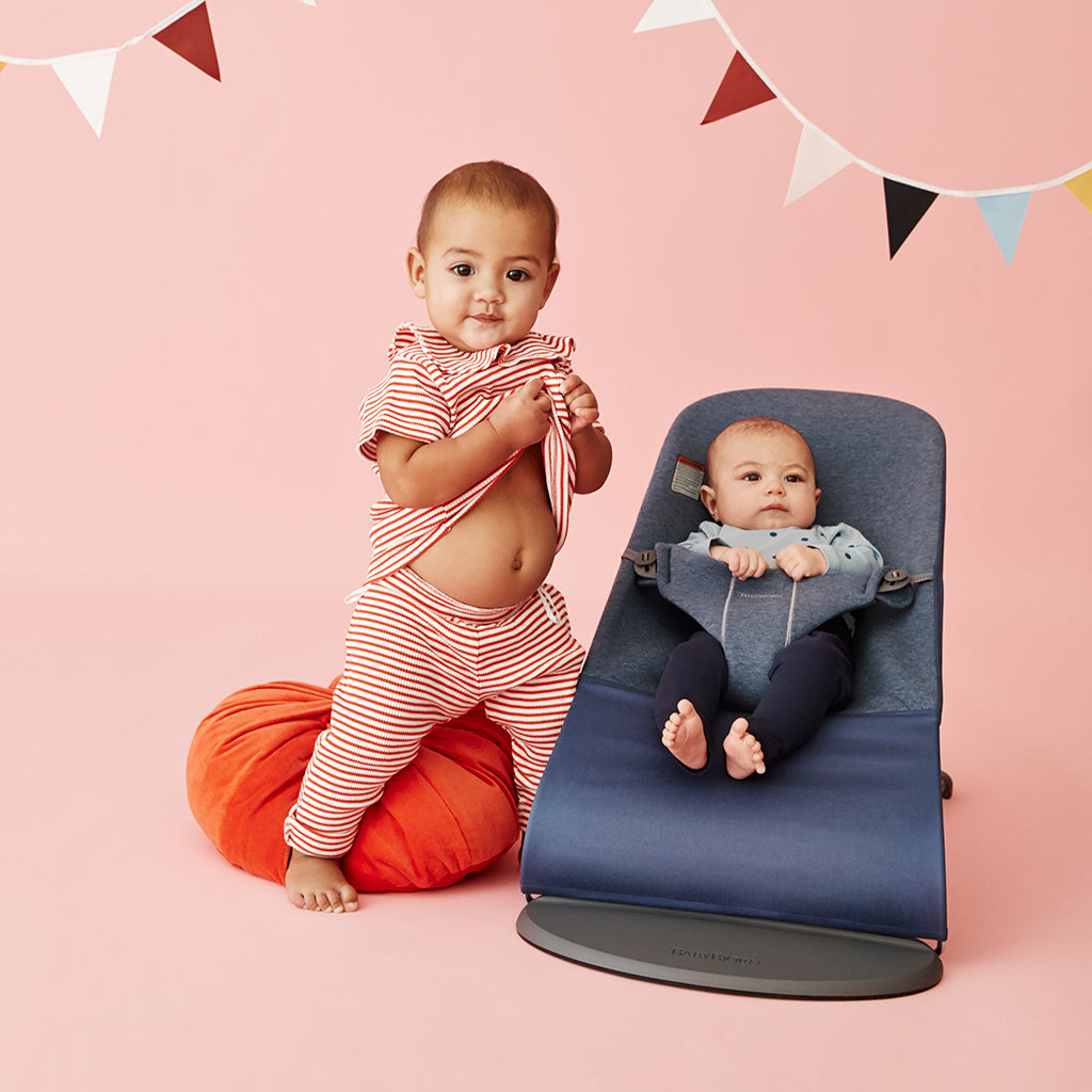infant with sibling in Babybjorn bouncer bliss in dove blue jersey fabric