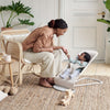 mom playing with baby in light beige bouncer bliss by BabyBjorn