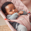 infant lying in baby bjorn bouncer bliss rose cotton quilt 