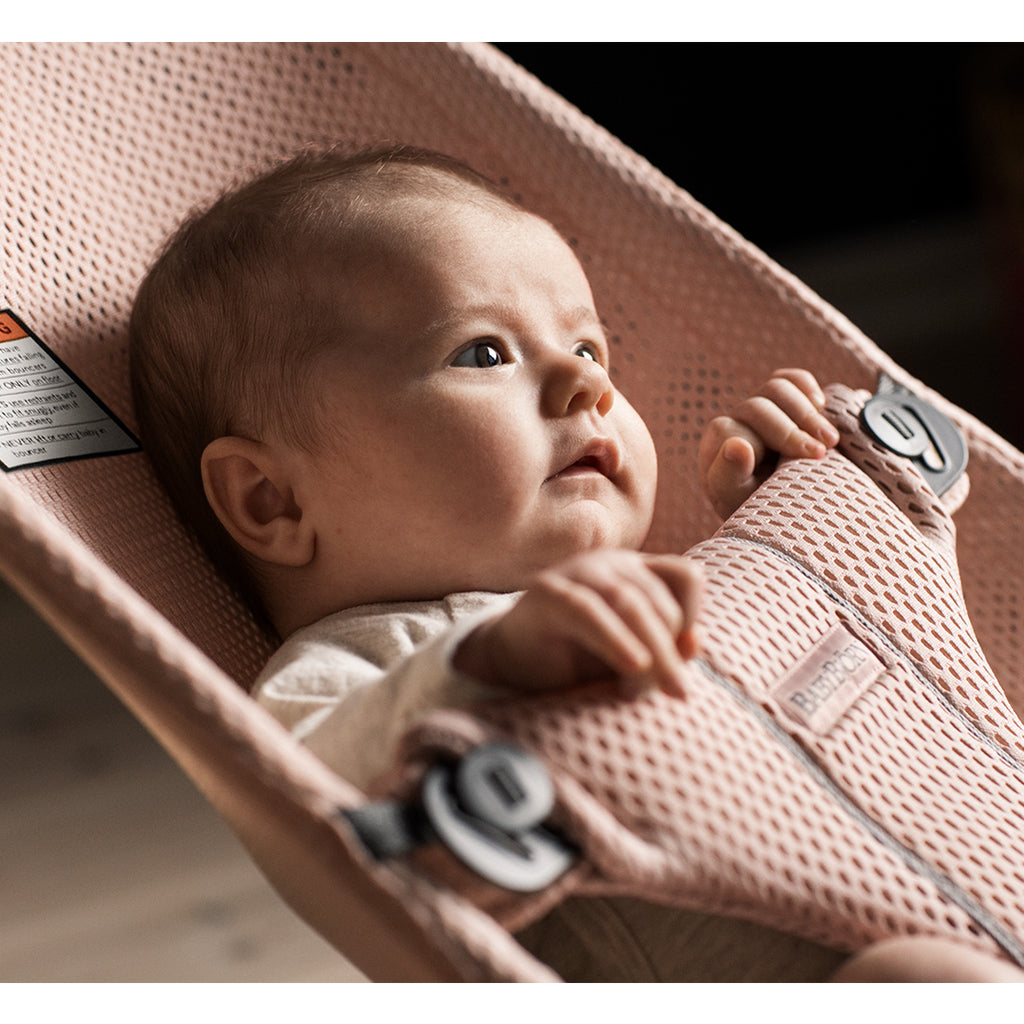 side view of baby in baby bjorn bouncer seat pink