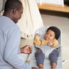 father smiling at baby in light grey petal quilt babybjorn bouncer bliss