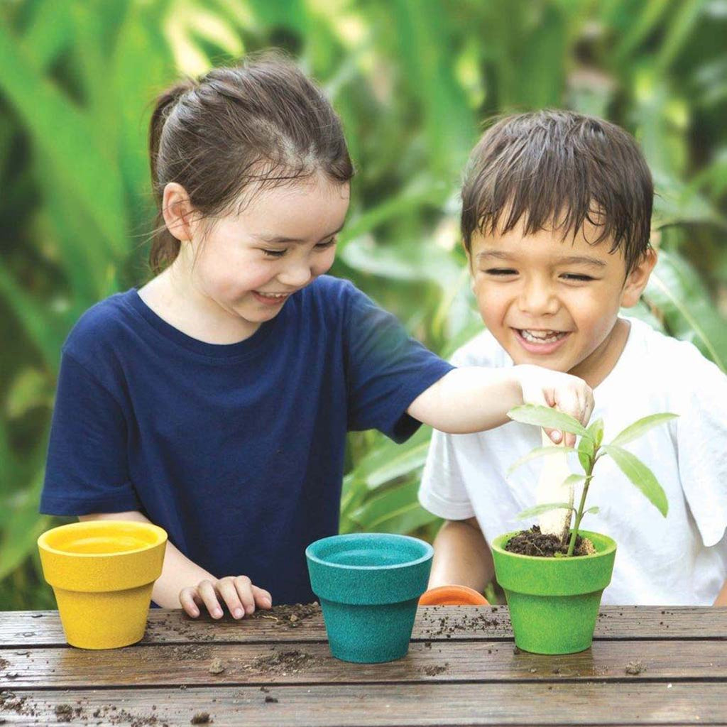 PlanToys Gardening Set Children's Outdoor Play Set. Modeled with two children taking care of a living plant.