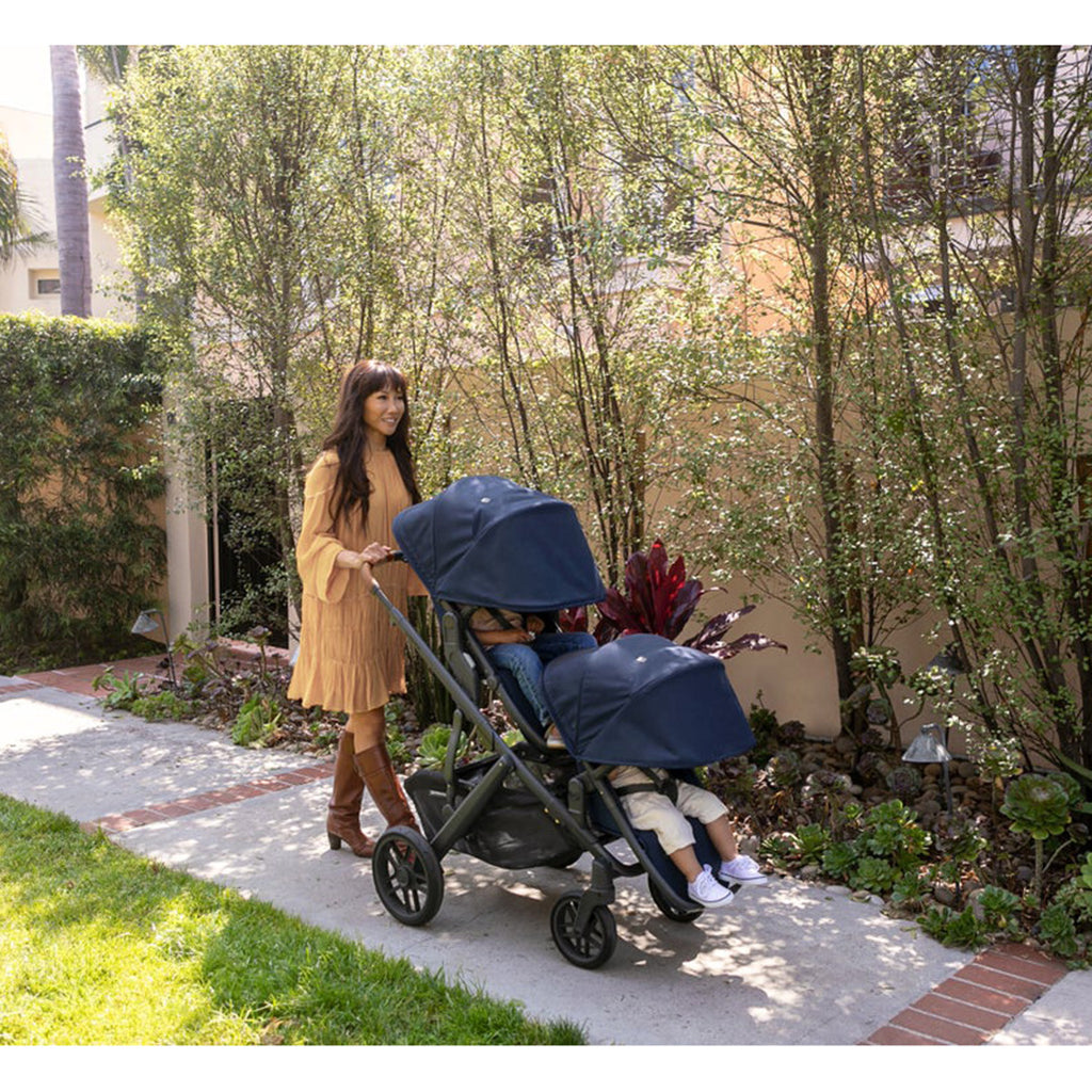 Woman pushing two kids in Uppababy VISTA V2 with Two Rumbleseats