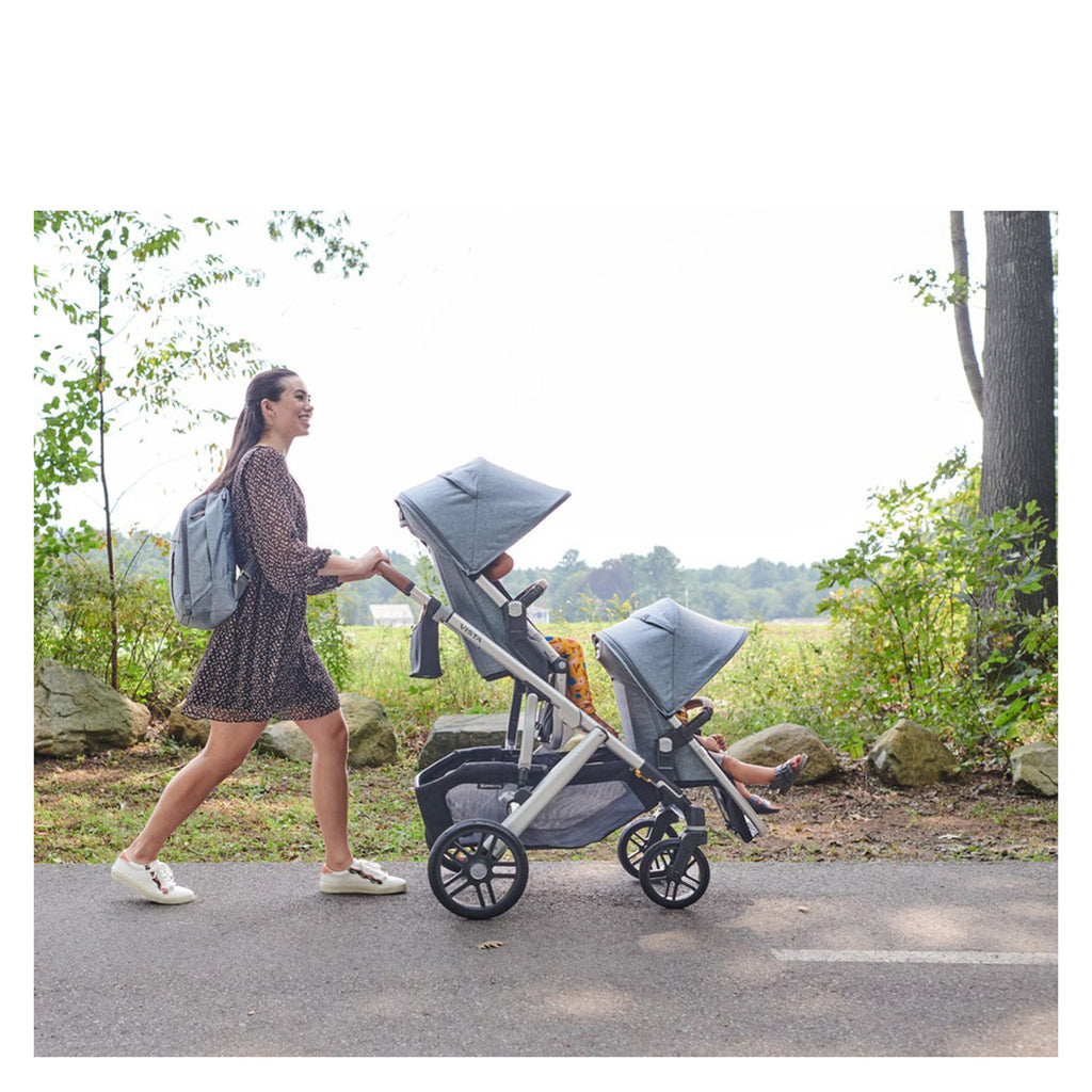 Woman walking with Vista Uppababy double stroller in Blue