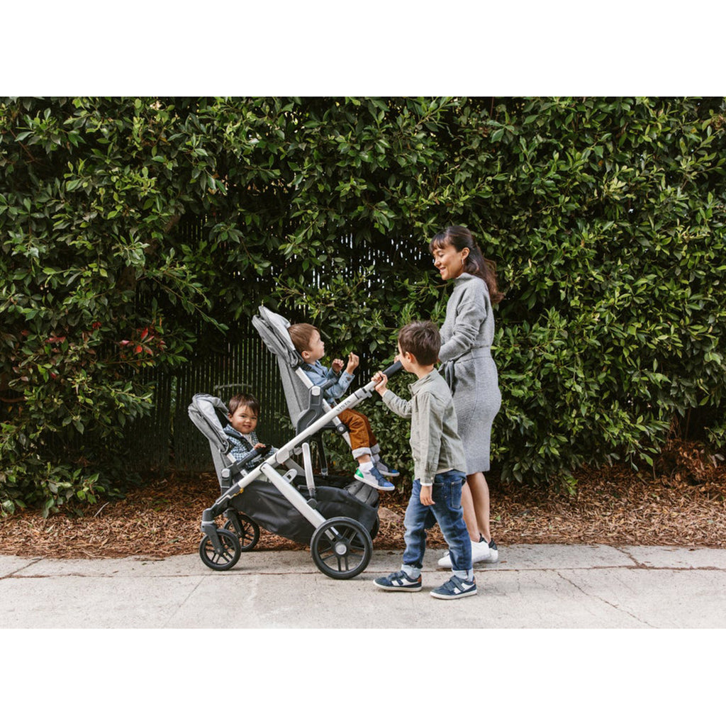 Mother walking with Three Children with Uppababy Vista V2 with two rumble seats