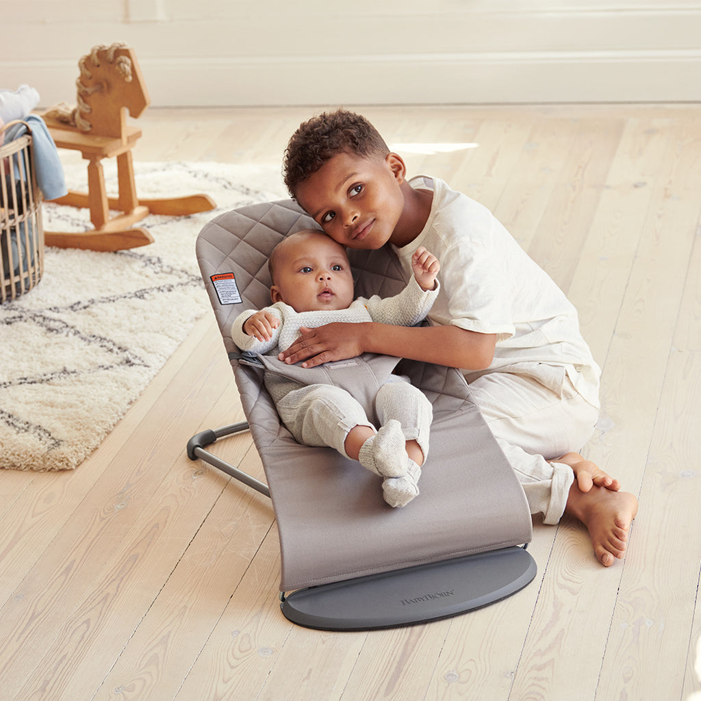 baby and brother hugging in baby bjorn bouncer bliss in sand grey