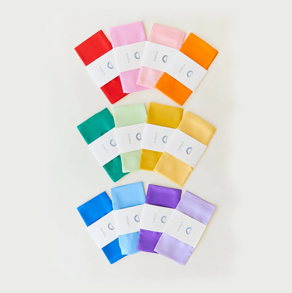Flatlay of 12 of the color variations of Sarah's Silks Playsilks in their packaging.
