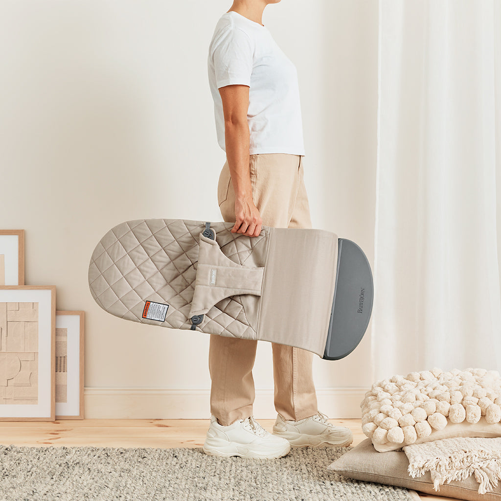 parent holding babybjorn baby bouncer seat sand grey cotton