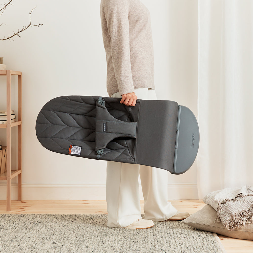 parent lifting folded baby bjorb bouncer for infants in anthracite
