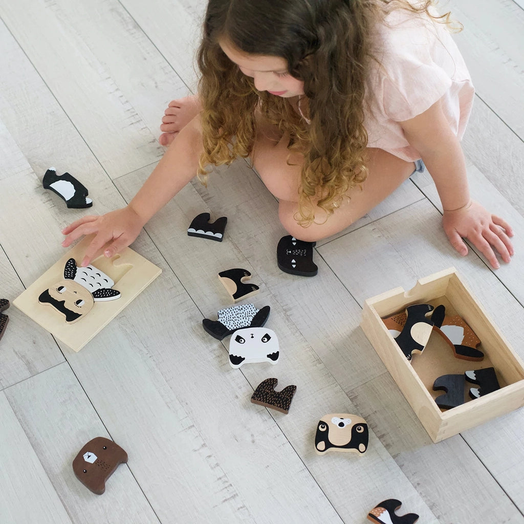 Wee Gallery Mix & Match Animal Tiles Wooden Dress Up Play Set. Lifestyle image of a child playing with the animal tiles.